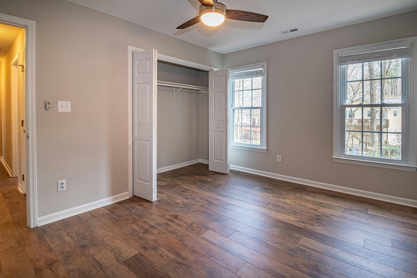 Chambre vide lumineuse avec parquet, prête pour un état des lieux